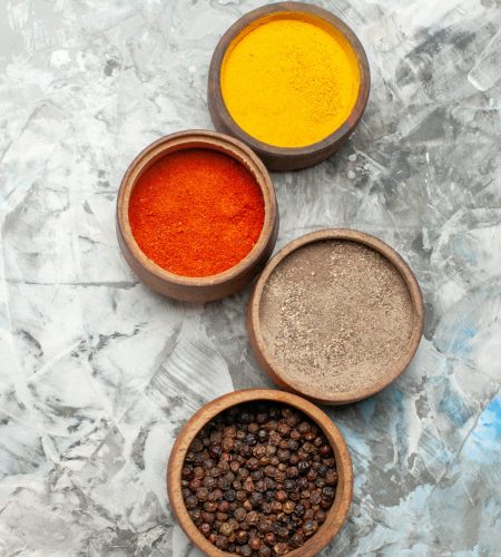 vertical-view-different-spices-brown-bowls-gray-background